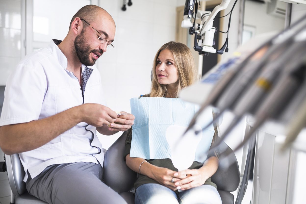 Orthodontist talking with a patient in the treatment chair